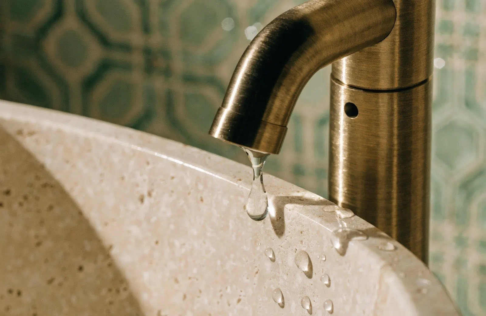 Détail de robinetterie laiton brossé posée lors d'une rénovation de salle de bain haut de gamme